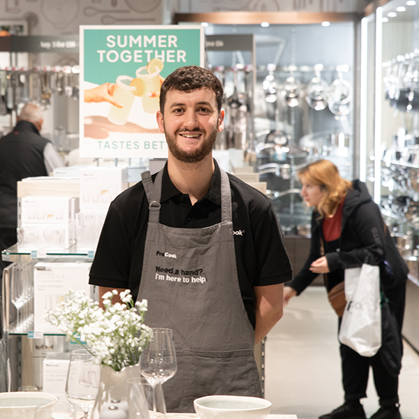 ProCook staff member smiling at the camera while standing in a store